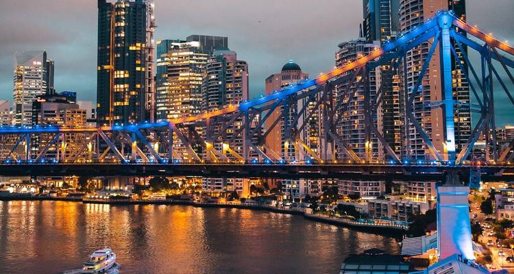 Stadsgezicht bij nacht met een verlichte brug.