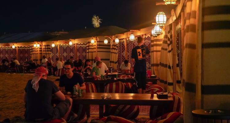 Gruppenessen in einem traditionell dekorierten Zelt bei Nacht