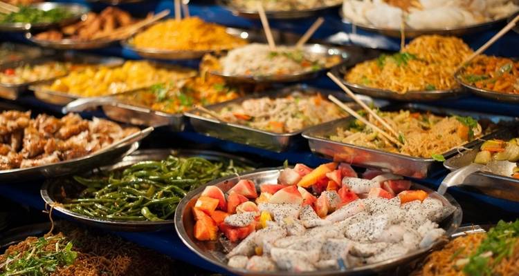A variety of colorful dishes displayed at a food market.