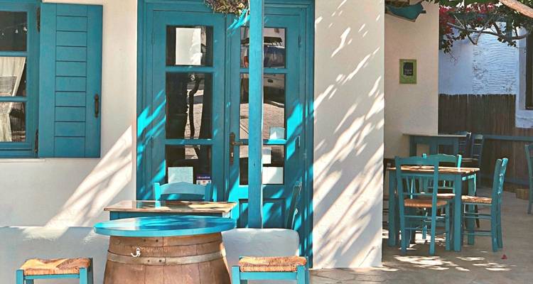 A traditional Greek cafe with blue shutters.