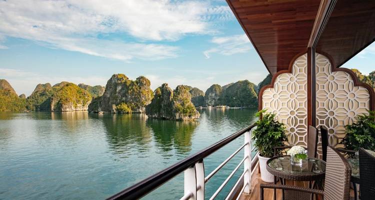 Schilderachtig uitzicht vanaf een cruisebalkon op kalksteeneilanden in rustig water.