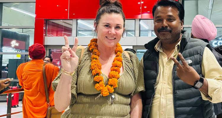 Personne avec une guirlande de fleurs posant à l'entrée