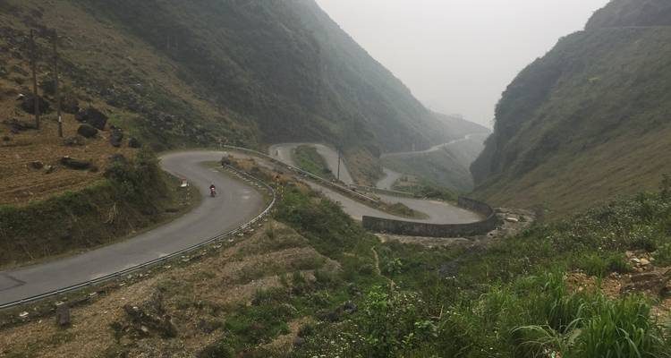 Eine kurvenreiche Straße durch ein bergiges Tal.