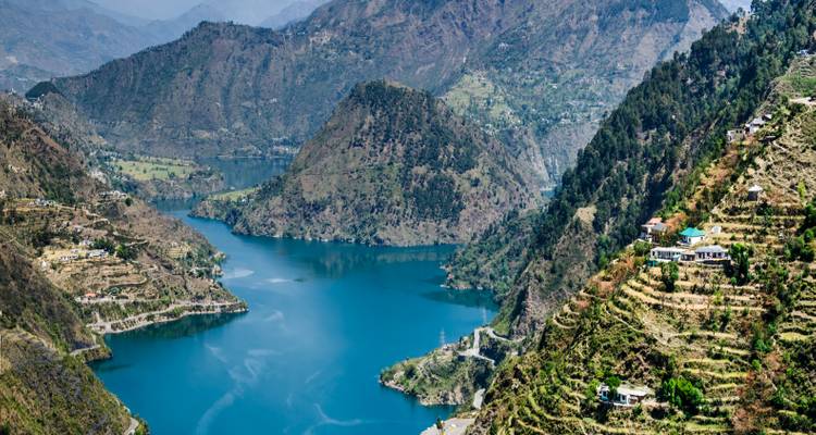 Panoramisch uitzicht op een rivier die kronkelt door bergachtig terrein met weelderig groen.