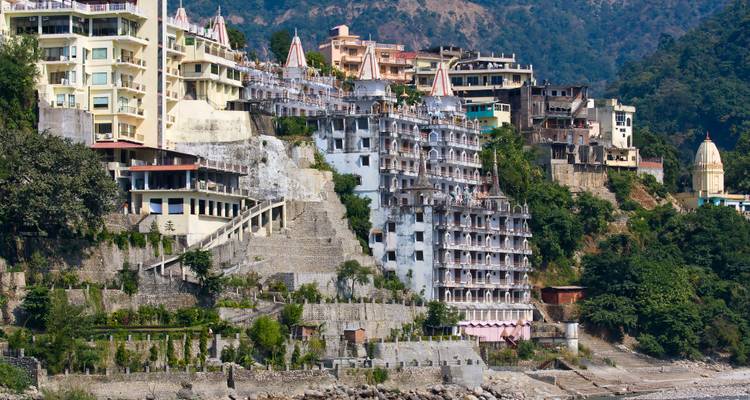 Stad op een heuvel met meerverdiepige gebouwen die als een waterval langs de helling naar beneden lopen naast een rivier.