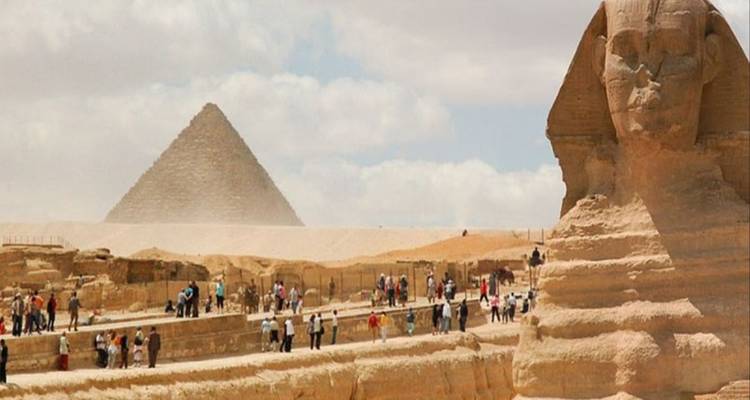 Mensen die de Sfinx bezoeken met piramides op de achtergrond