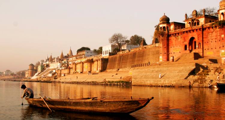 Ein Blick am Flussufer mit einer historischen Stadtansicht und Booten.