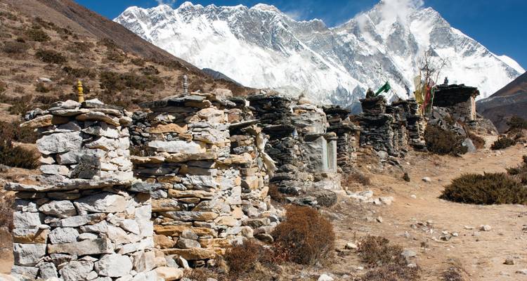 Ein abgelegenes Dorf mit Steinbauten und verschneiten Bergen.