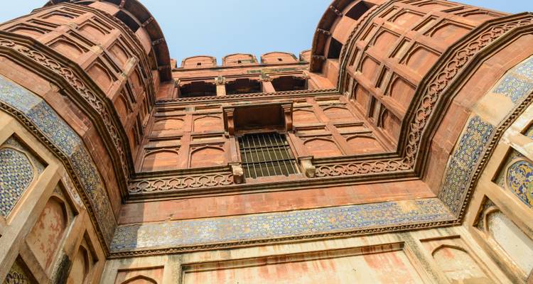 Blick nach oben auf eine rote burgähnliche Struktur mit detaillierter Verzierung.