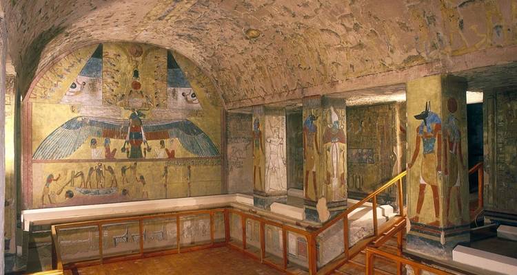 Interior de una tumba del antiguo Egipto con jeroglíficos y tallados coloridos.