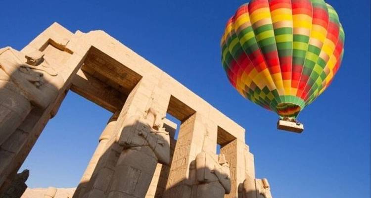 Heteluchtballon die zweeft boven oude Egyptische ruïnes.