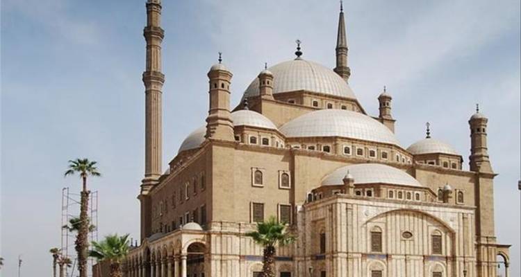 Eine große Moschee mit Kuppeln und Minaretten unter einem blauen Himmel.