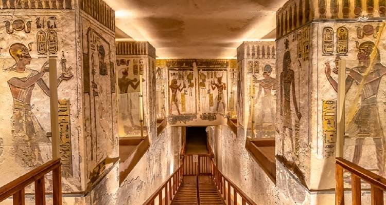 Corridor inside an Egyptian tomb with vibrant wall art and inscriptions