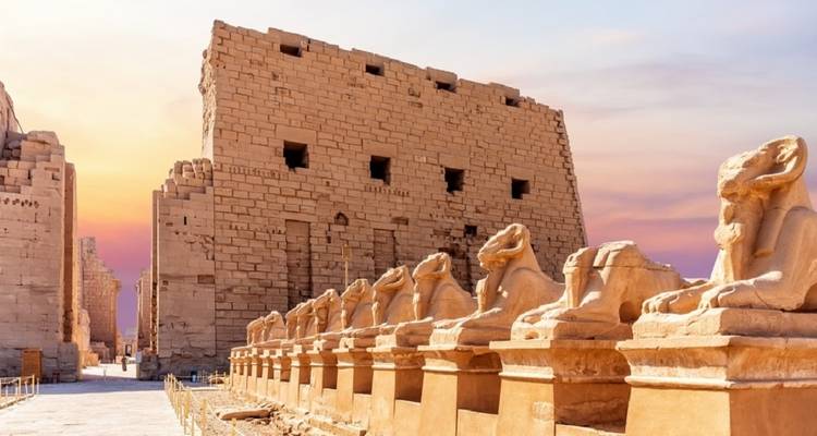 Reihen von Statuen, die zu einem Tempeleingang in Karnak führen.