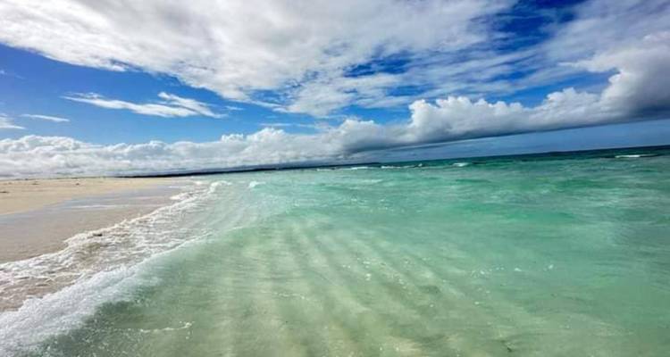 Eine atemberaubende Aussicht auf klares blaues Wasser, das am Horizont auf den Himmel trifft.