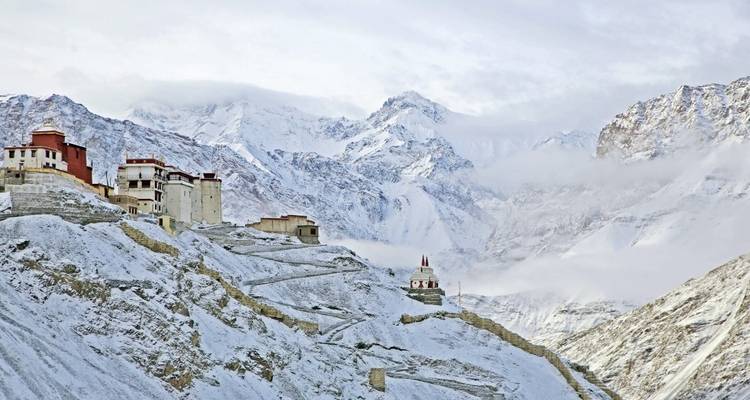 Mountainous landscape with monastery in snow.