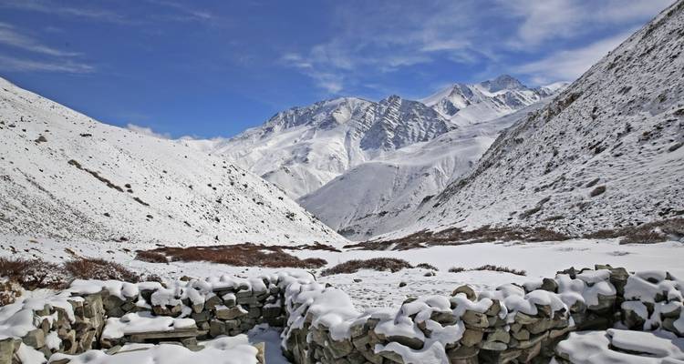 Stone wall in a snowy mountain valley.