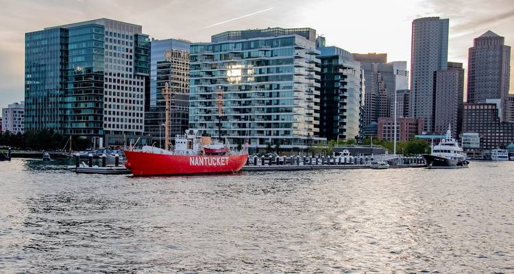 Städtischer Hafen mit einem roten Schiff und modernen Gebäuden.