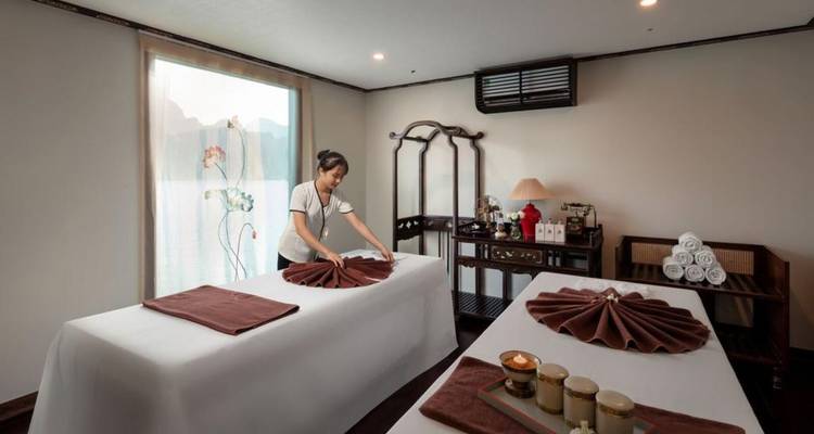 Spa-ruimte met massagetafels en schilderachtig uitzicht op water door de ramen.