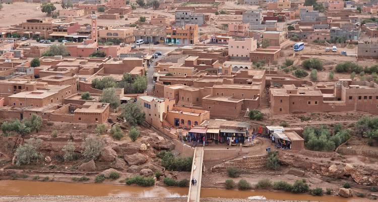 Une vue sur une ville marocaine avec des bâtiments aux toits plats et des montagnes au loin.