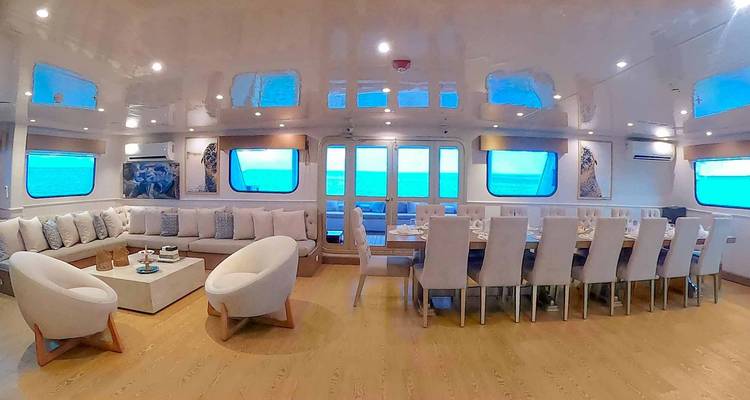 Interior amplio que combina la sala de estar y el comedor con grandes ventanas que muestran el océano.