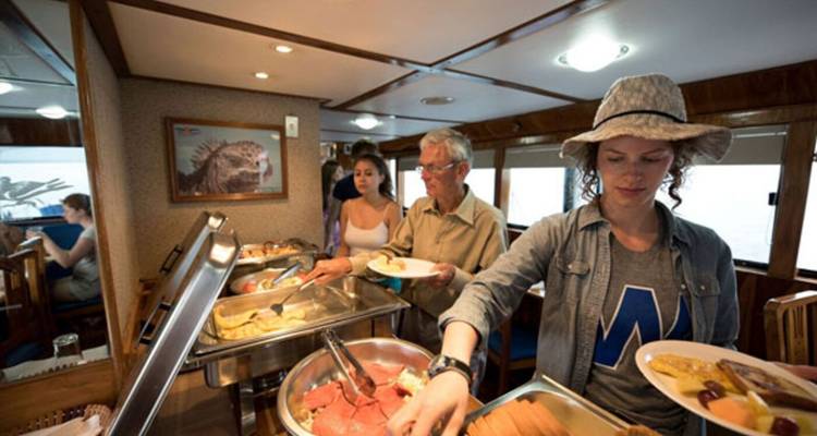 People serving themselves food at a buffet on a boat.