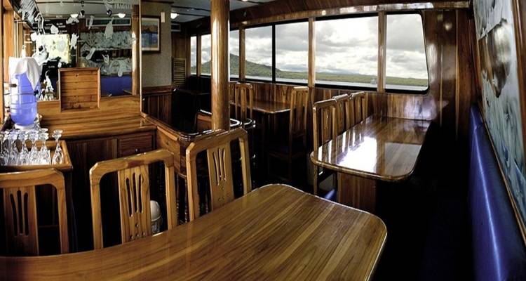 Dining area on a boat with a view of the sea.