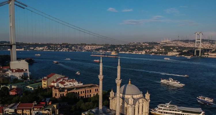 Bosphorus Strait with ferries and a view of a suspension bridge.