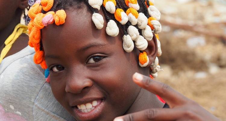 Close-up of a child with colorful beads in their hair.