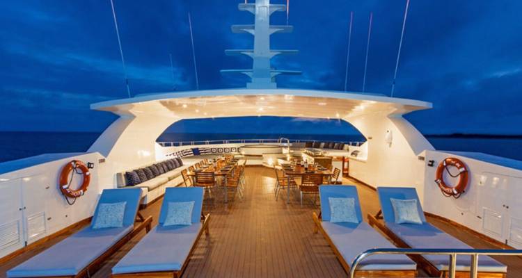 Deck einer Yacht mit Sonnenliegen in der Abenddämmerung.