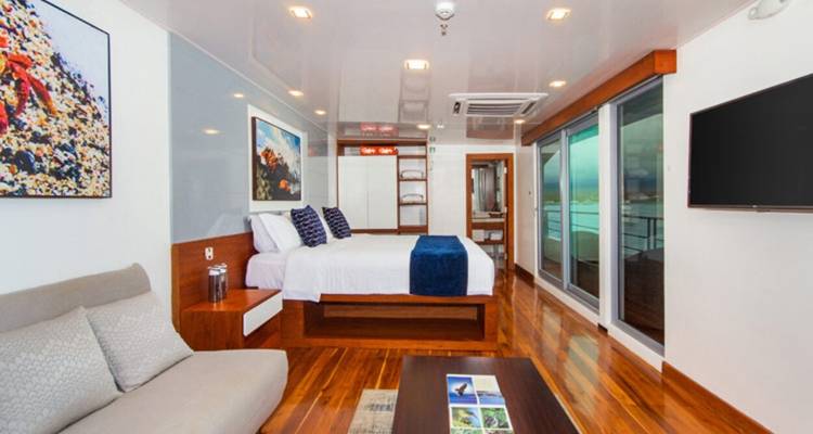 Geräumiges Zimmer mit Bett und Balkonblick auf einer Yacht.