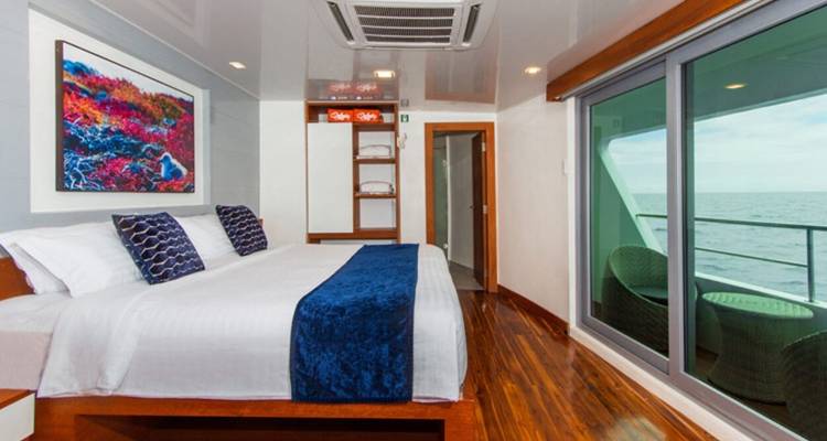 Großes Bett in einer modernen Yachtkabine mit Balkonblick.