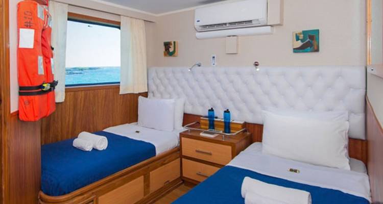 Gemütliche Zweibettkabine mit Meerblick auf einer Yacht.