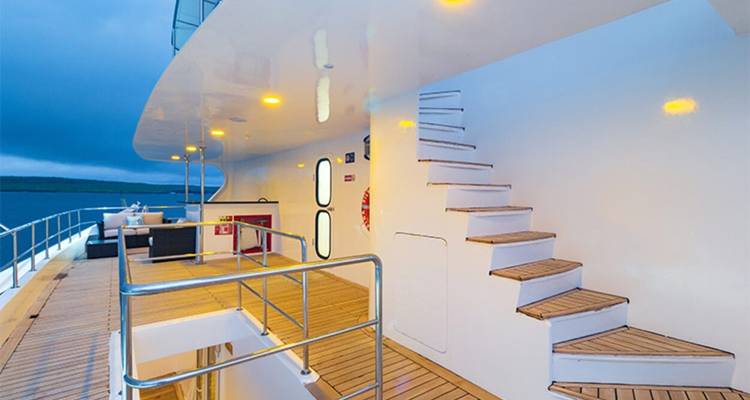 Deckbereich einer Yacht mit Treppen und Geländern.