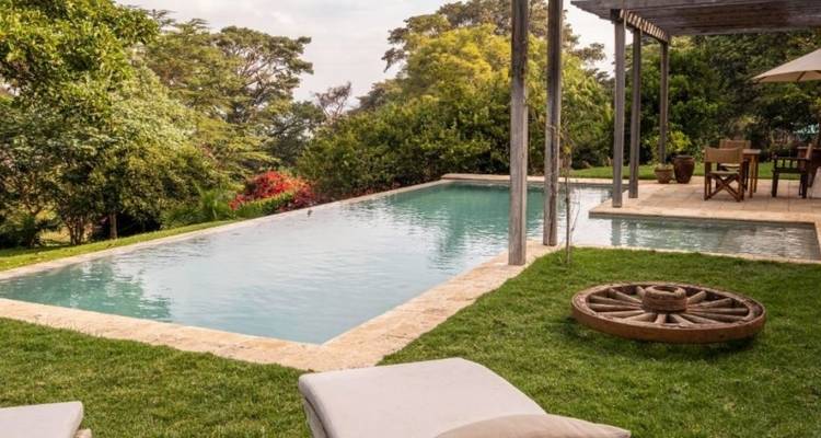 Schwimmbad mit Bäumen und Blumen in einer ruhigen Umgebung.