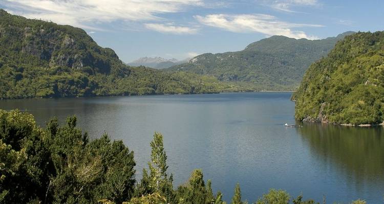 Blick auf einen ruhigen See, umgeben von Bergen in Chile.