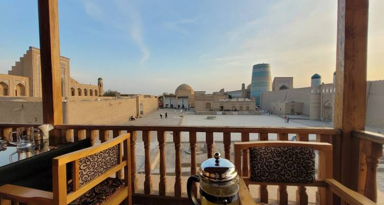 Vue depuis un balcon donnant sur des bâtiments anciens et un minaret.