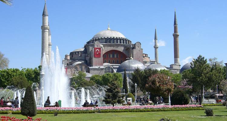 Fountains and Hagia Sophia with people in a park.
