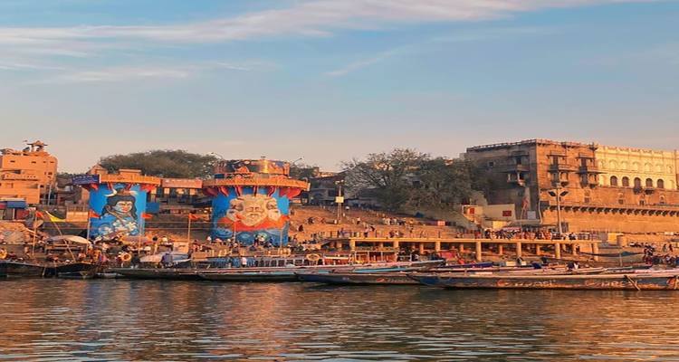 Flussufer mit bunten Graffiti und Booten auf dem Wasser.