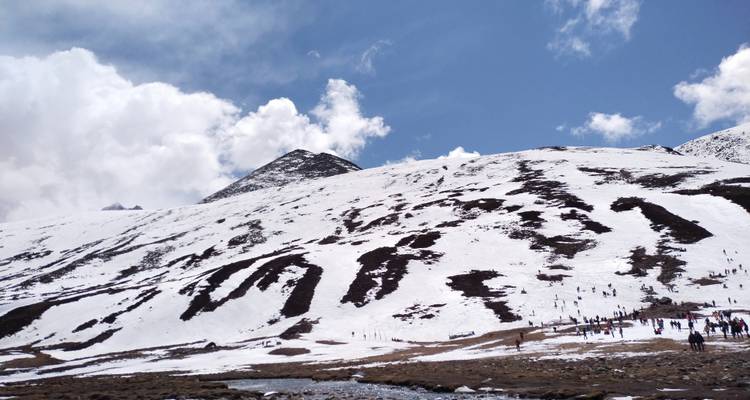 Paysage de montagne enneigé avec des personnes en randonnée.