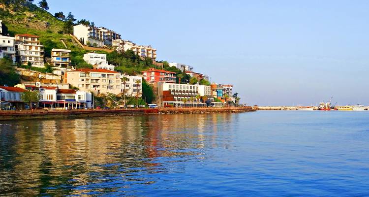 Malerische Aussicht auf eine Küstenlinie mit lebendigen Gebäuden und ruhigem Meer.