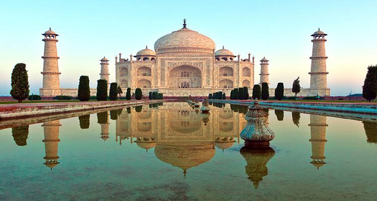 Taj Mahal mit einem spiegelnden Wasserbecken bei Tageslicht.