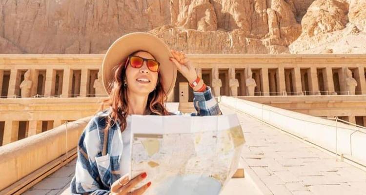 Mujer con un mapa en la mano, explorando el sitio histórico del Templo de Hatshepsut.