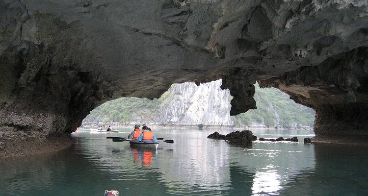 Individual canoeing through a cave with limestone formations.