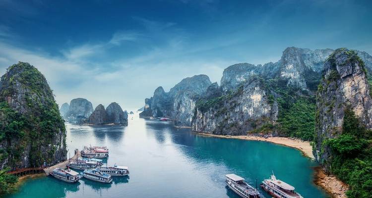 Breathtaking view of a bay with steep cliffs and boats, seen from an elevated point.