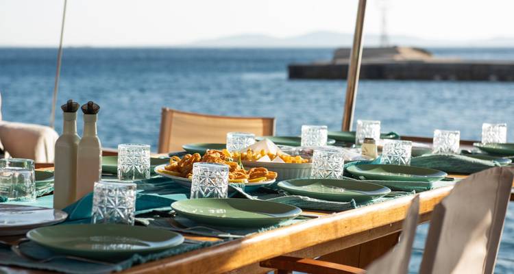 Mesa puesta en cubierta con vista al mar.
