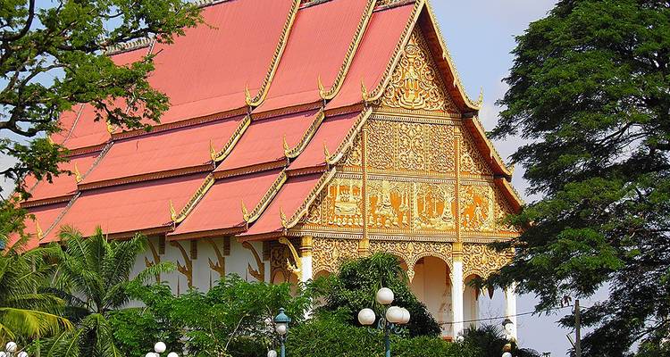 Tempel mit verzierter Goldfassade und Laub.