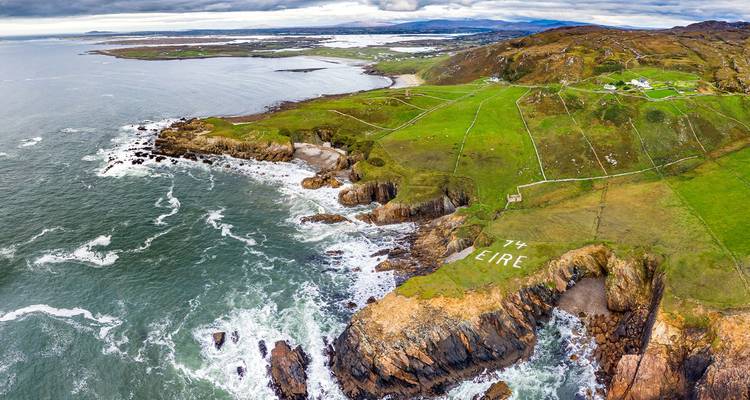 Luchtfoto van de ruige kust van Donegal met 'EIRE 74' markeringsbord uit de oorlogstijd op de klif.
