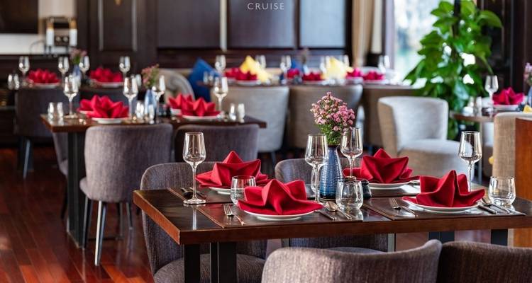 Eetruimte op een cruiseschip met tafels gedekt voor de maaltijd.