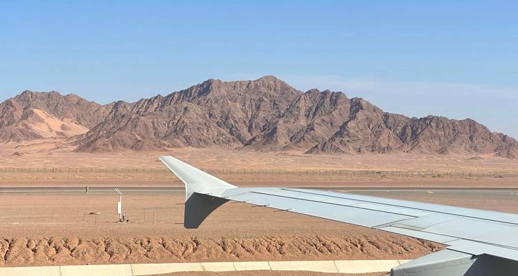 Vue depuis un avion d'un paysage désertique avec des montagnes.